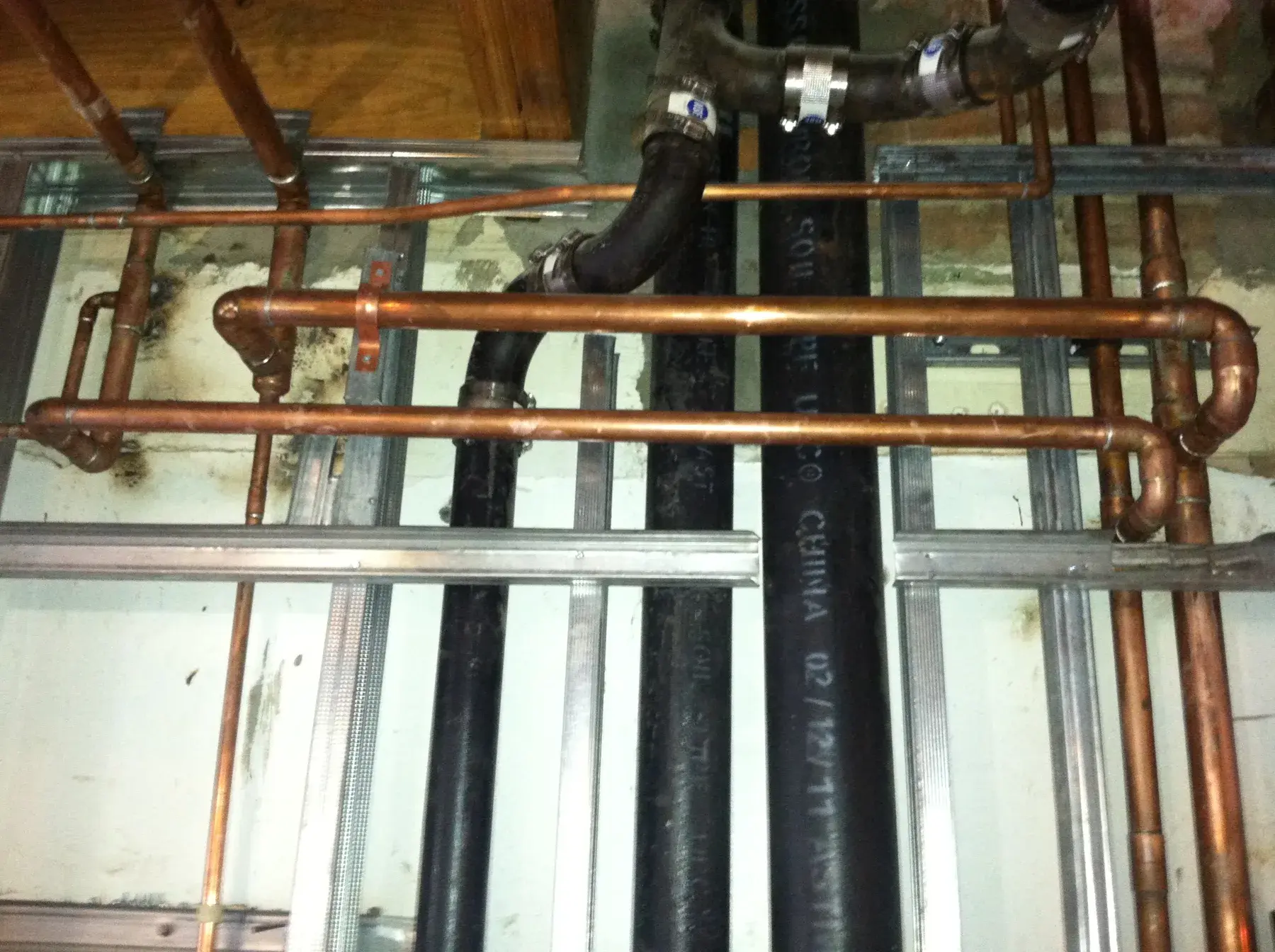 Copper plumbing rough-in installed between open wall studs